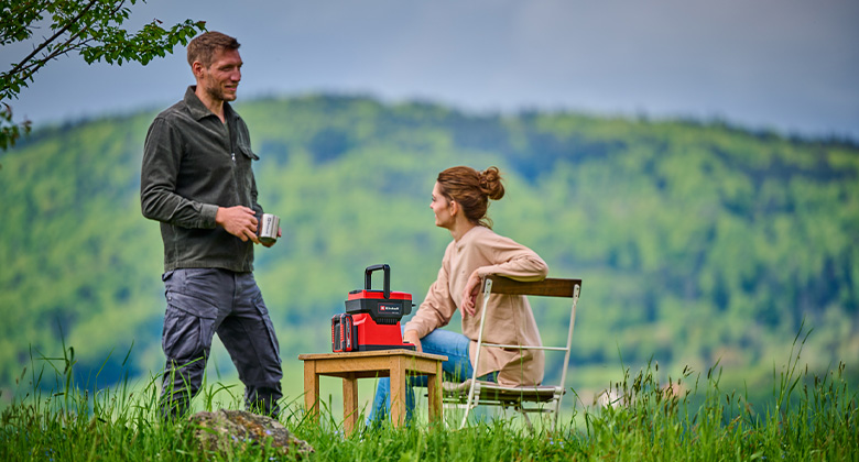 A man and a woman using the cordless coffee maker.