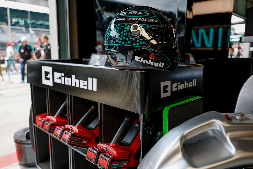 Ferramentas sem fios Einhell num carrinho, com um capacete de corrida em cima.